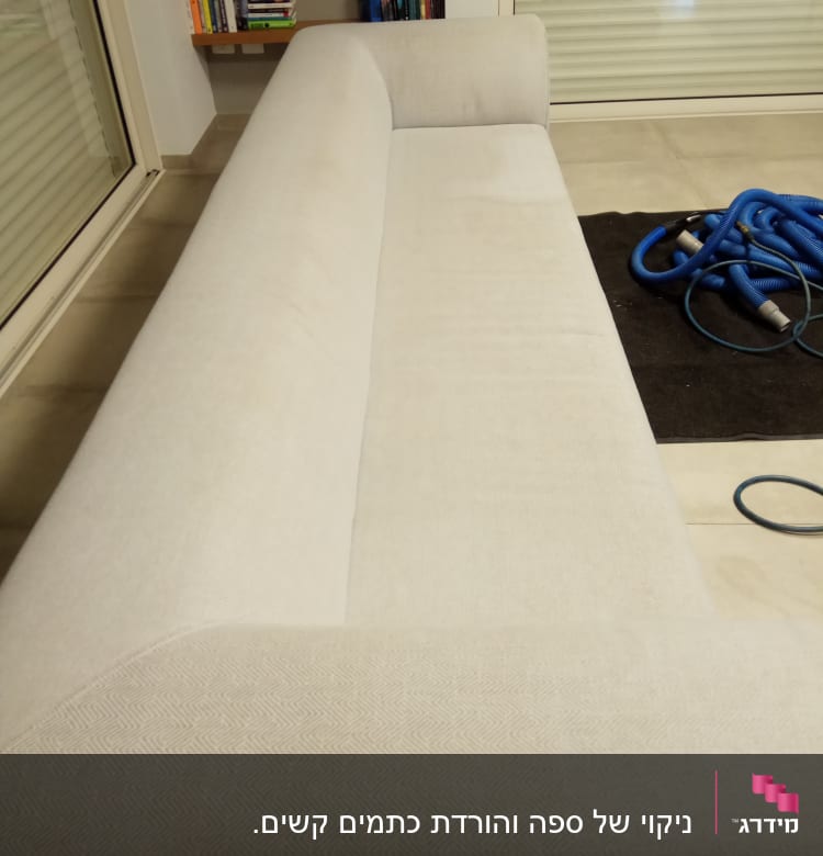 ספה בהירה עם צינורות ניקוי כחולים על הרצפה